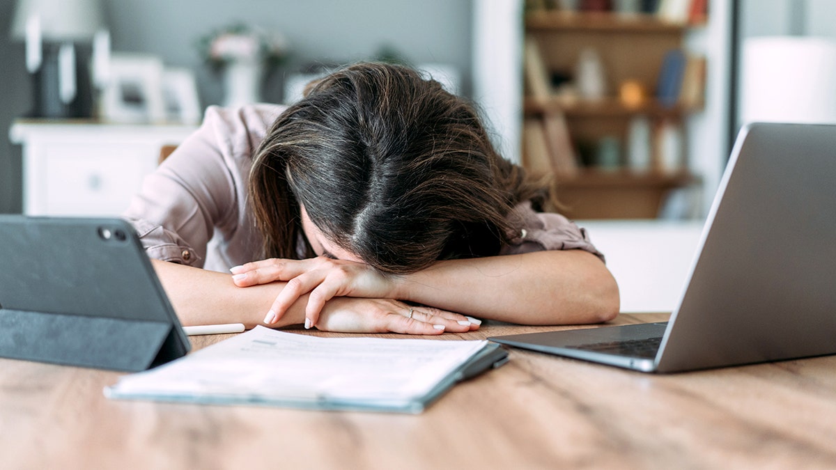 Shot of businesswoman sleeping on his desk while working from home.