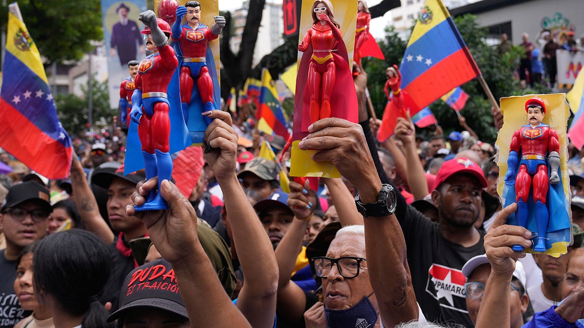 Venezuelan government supporters on the street waving signs in support of Nicolas Maduro
