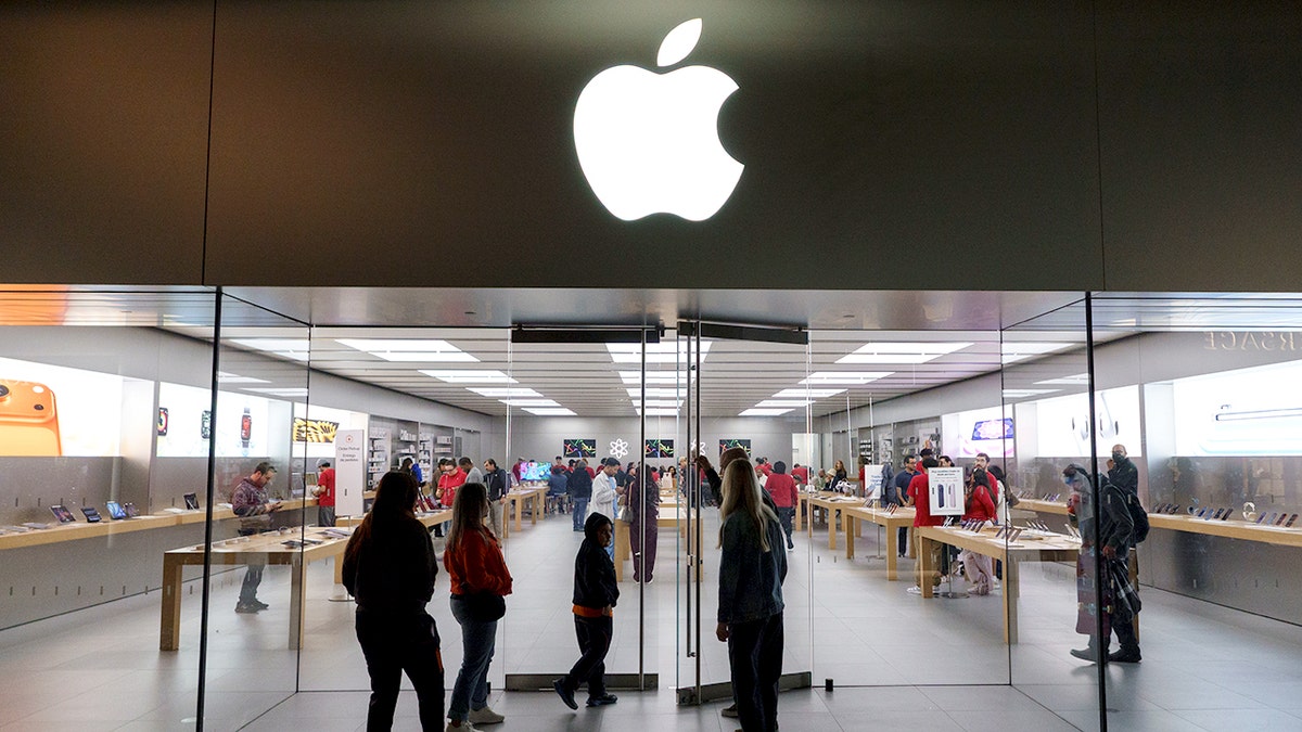 People stand outside of an Apple store.