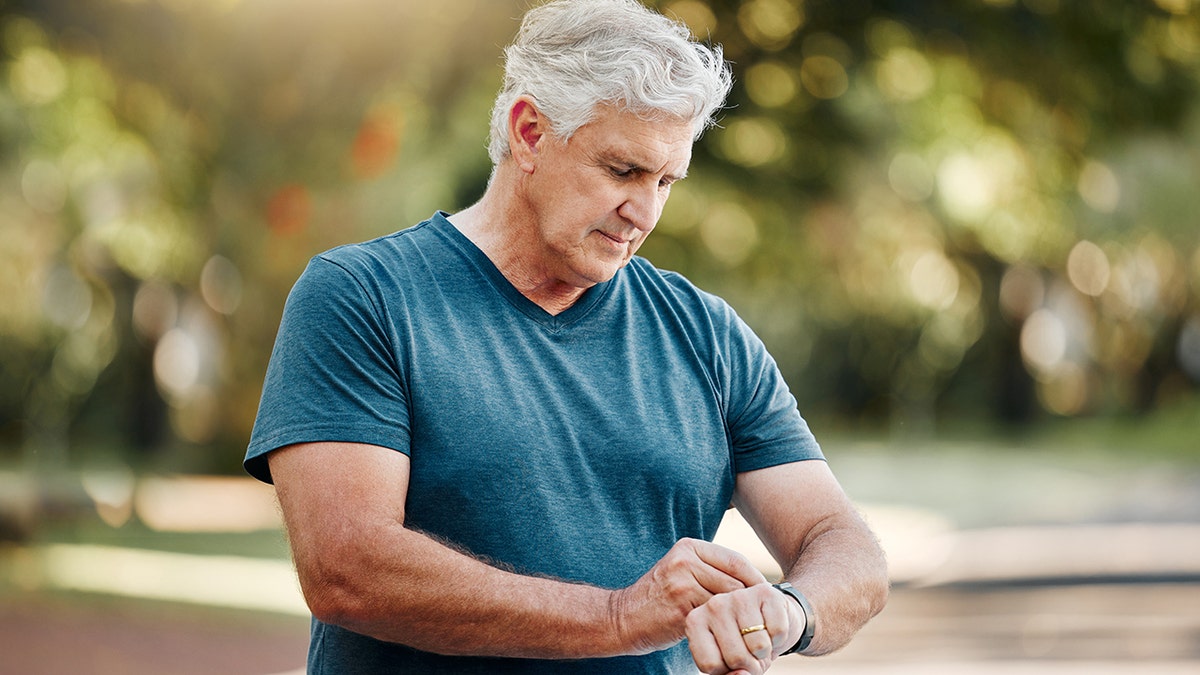 senior man checks watch on his wrist