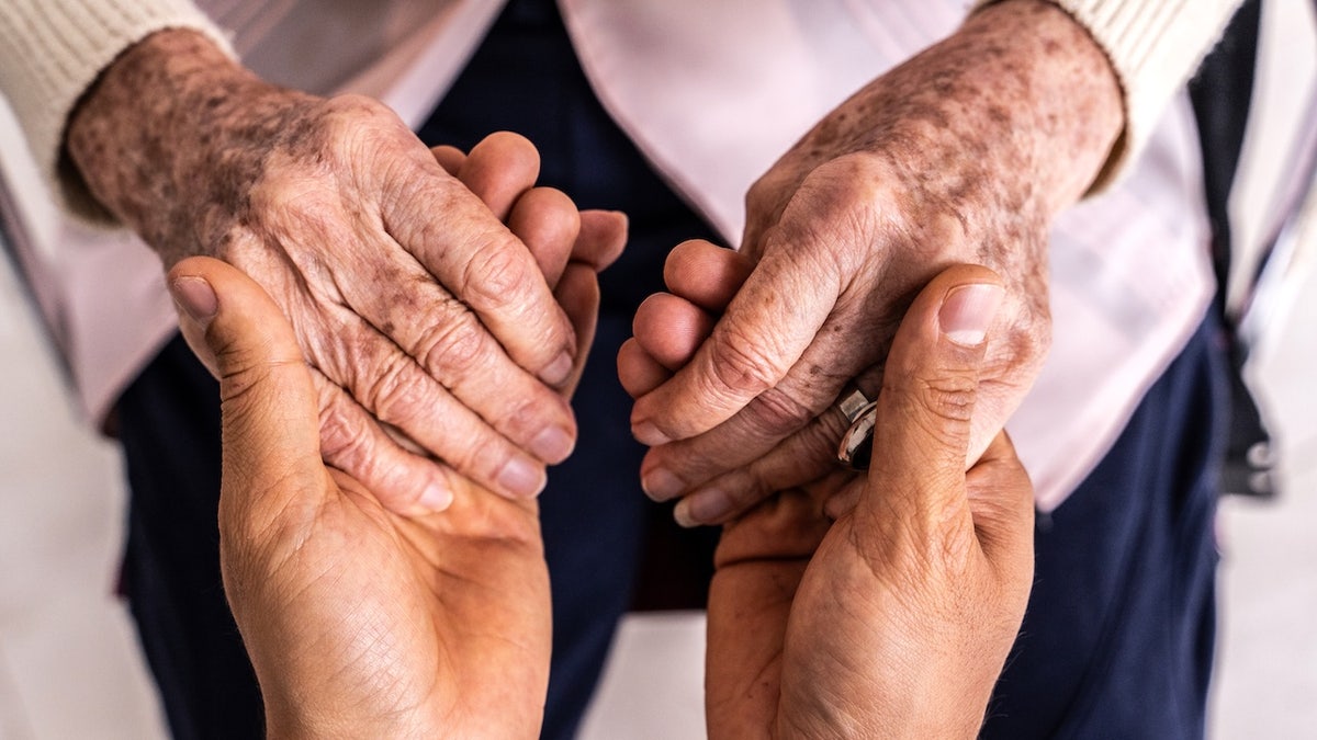 Person holding older person's hands - senior health and longevity