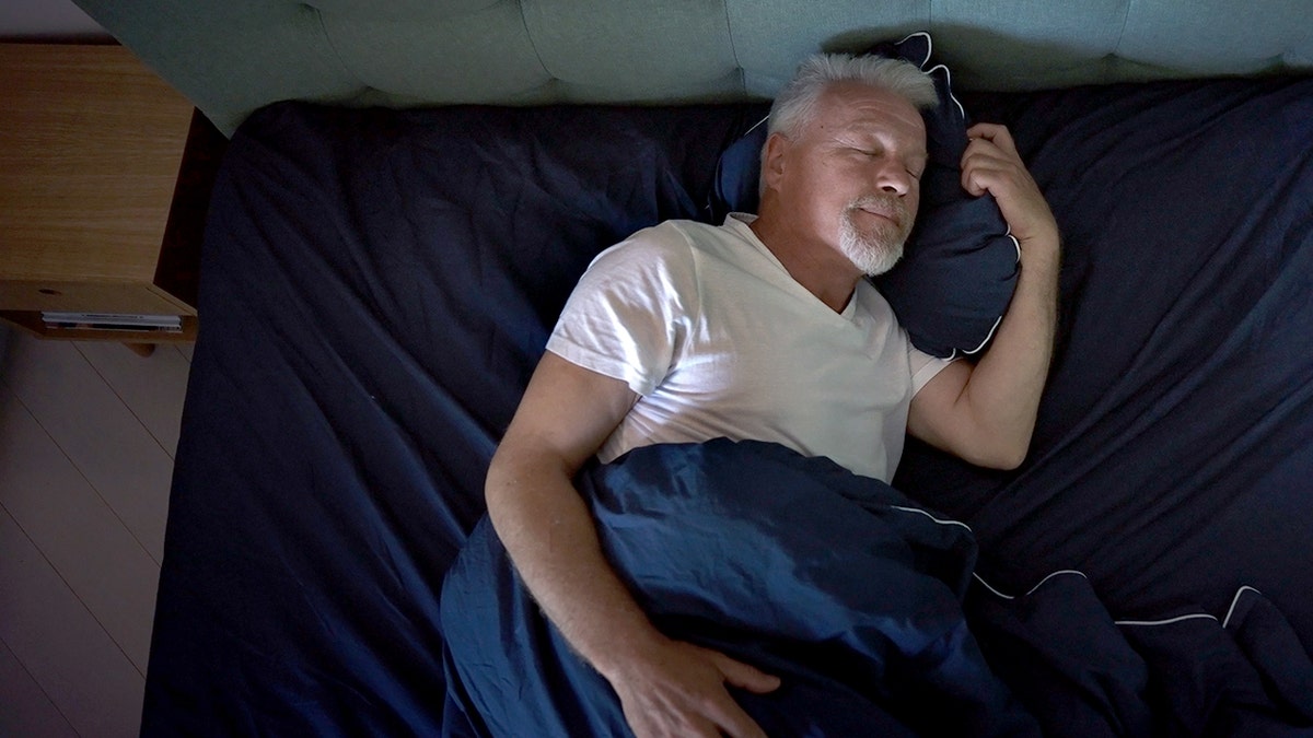 Man half-asleep in his bed, shot from the ceiling