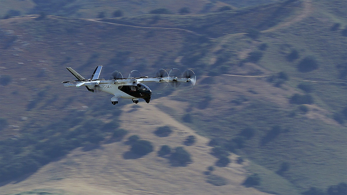 An air taxi flying over a mountain