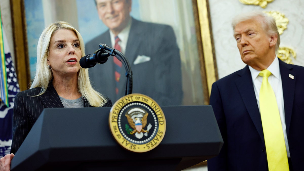 Attorney General Pam Bondi speaks as President Donald Trump looks on