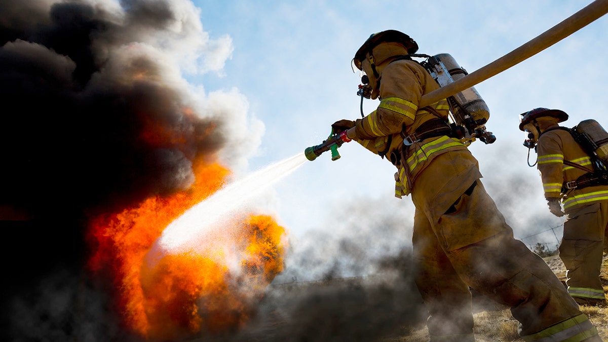 firefighters extinguish a fire with hose
