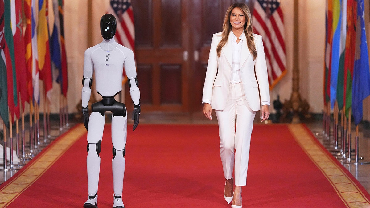 Melania Trump walking through the White House alongside a humanoid robot.