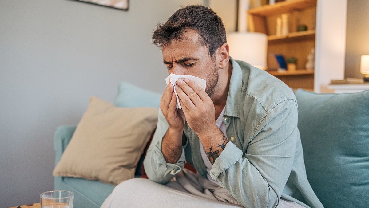 sick man blows nose