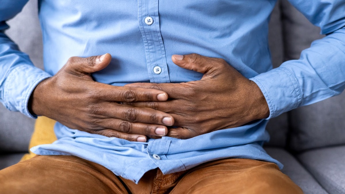 Man with stomach ache holding midsection