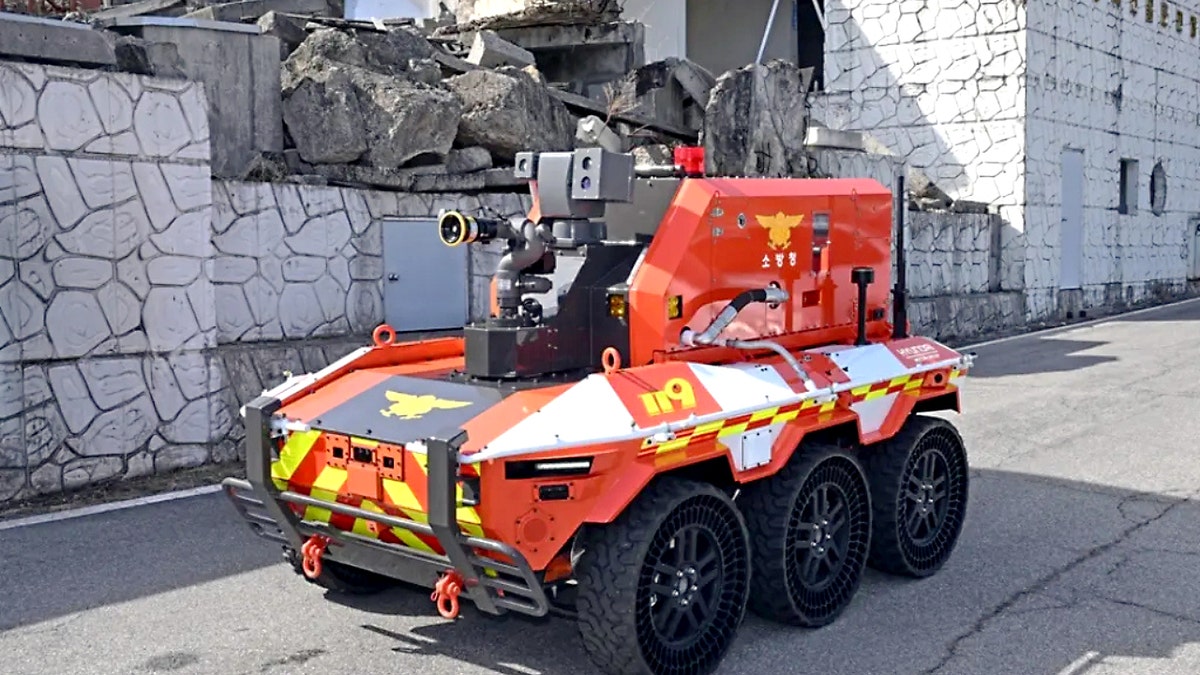 A Hyundai firefighting robot rolls down a road.