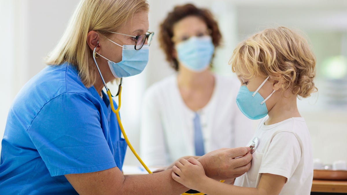 sick child is checked by doctor