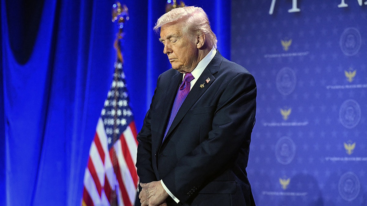 President Donald Trump bows his head in prayer at the National Prayer Breakfast in Washington, D.C.